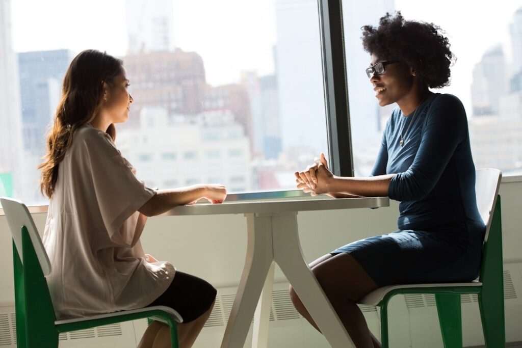 A calm, professional office with two people sitting across a mediator—symbolizing privacy and peace.