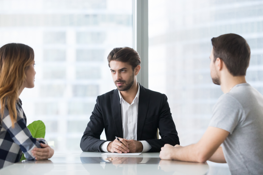 unhappy,husband,and,wife,consulting,lawyer,sitting,opposite,,young,married