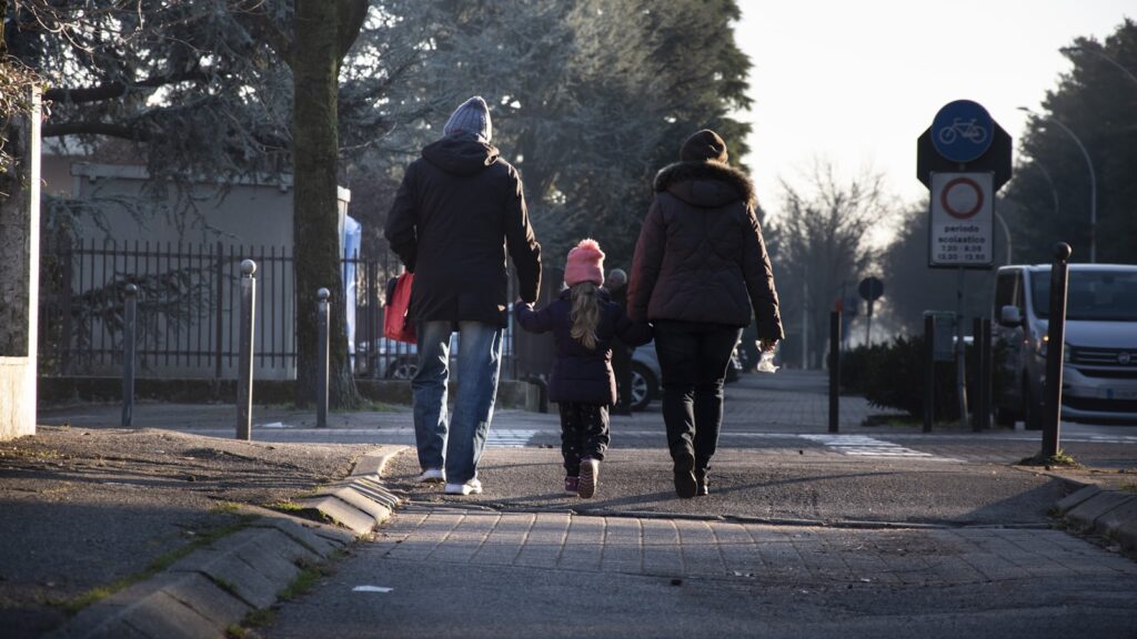 Two parents and their child walking together after custody mediation