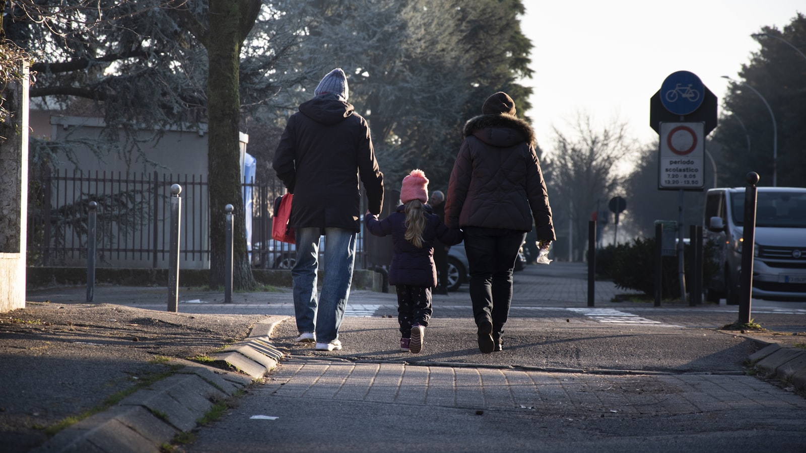 Two parents and their child walking together after custody mediation