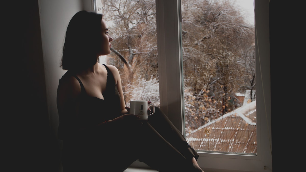 Woman by a window reflecting during the divorce mediation process