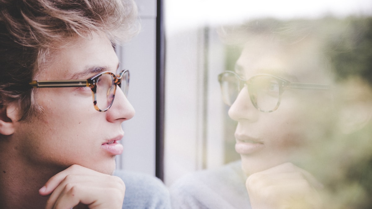 Service member reflecting at a window during a military divorce