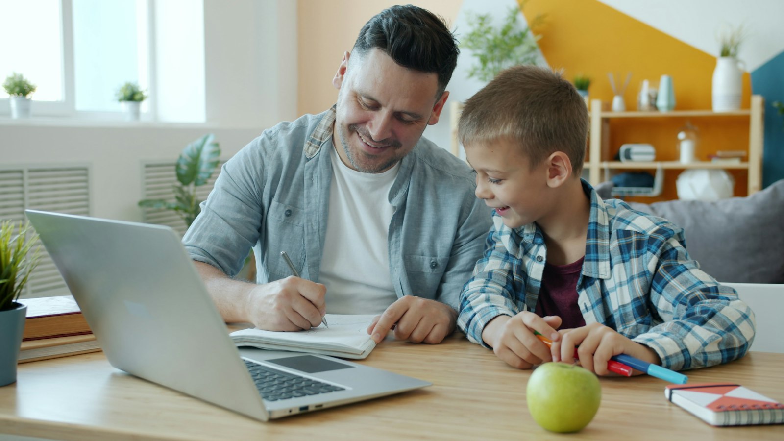 Parent and child working together at a desk, child support in divorce mediation
